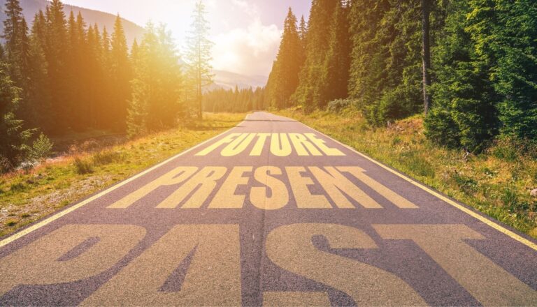 Mountain road labeled past, present, future at sunrise