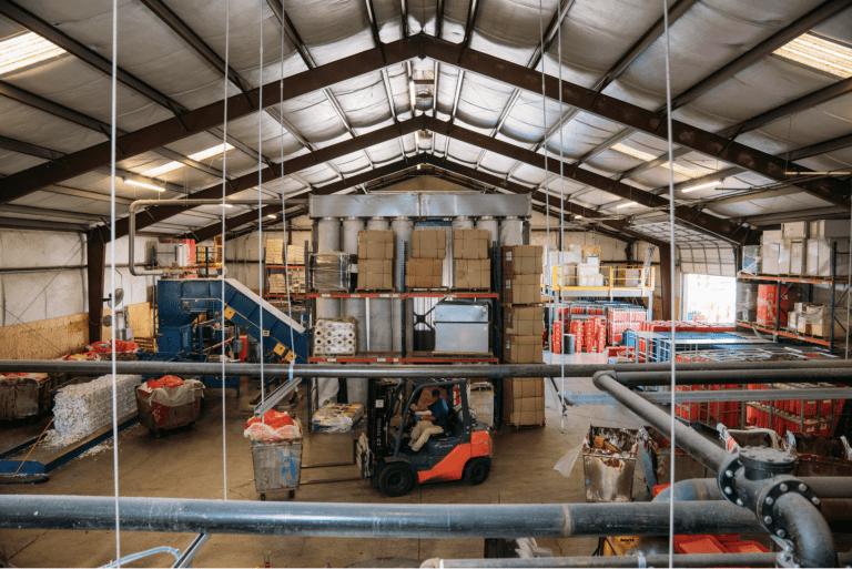 Industrial warehouse with forklift and stacked boxes.