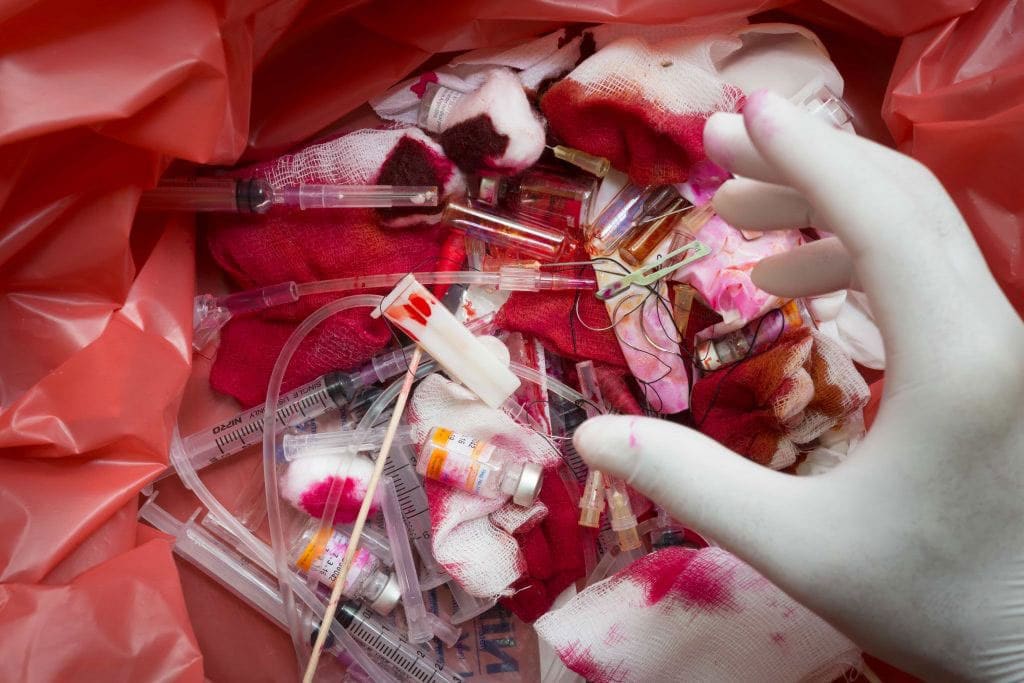 Medical waste with syringes and blood-stained gauze.
