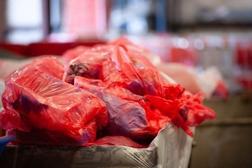 Red plastic bags stacked in storage area.