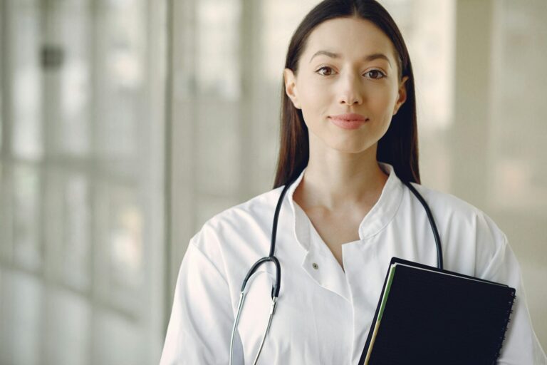 Female doctor with stethoscope in hospital corridor.