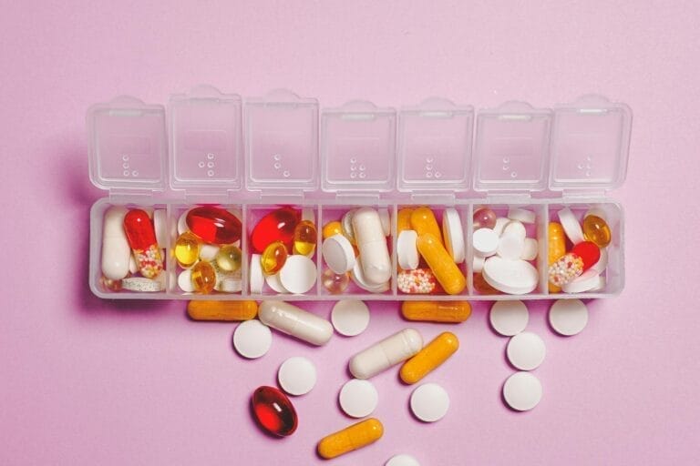 Assorted pills in a weekly pill organizer.