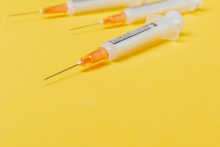 Syringes on yellow background, medical tools