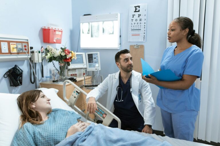 Doctors discussing patient care in hospital room.